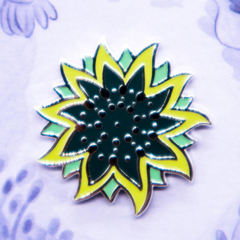 Vibrant green sunflower starfish hard enamel pin with green glow effect.