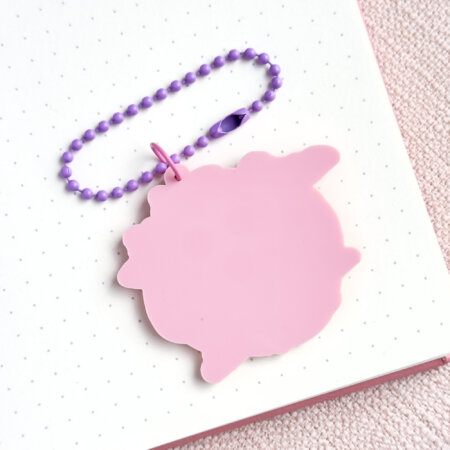 Back side of Lottie's "Witch's hat" acrylic charm. No print, just soft pink material.